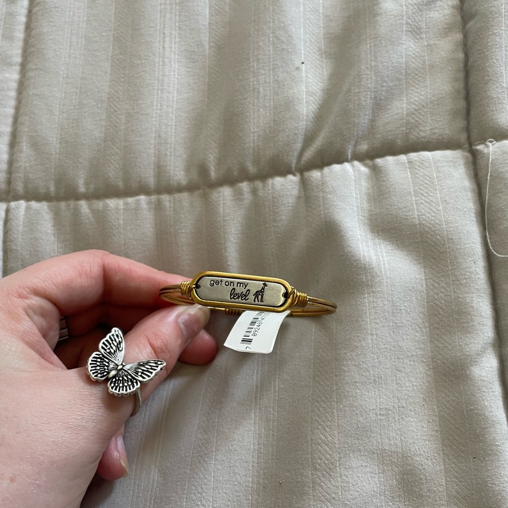 Gold bracelet that says Get on my Level with a giraffe next to the lettering